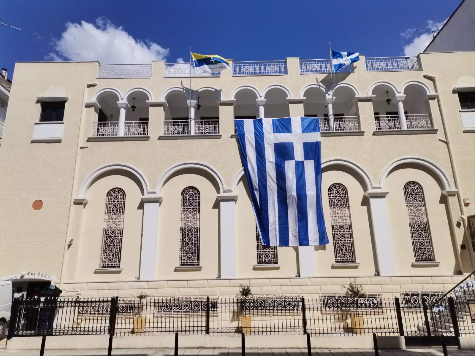 Το κτίριο του Προκοπείου Πολυδύναμου Εκκλησιαστικού Κέντρου με ελληνικές σημαίες